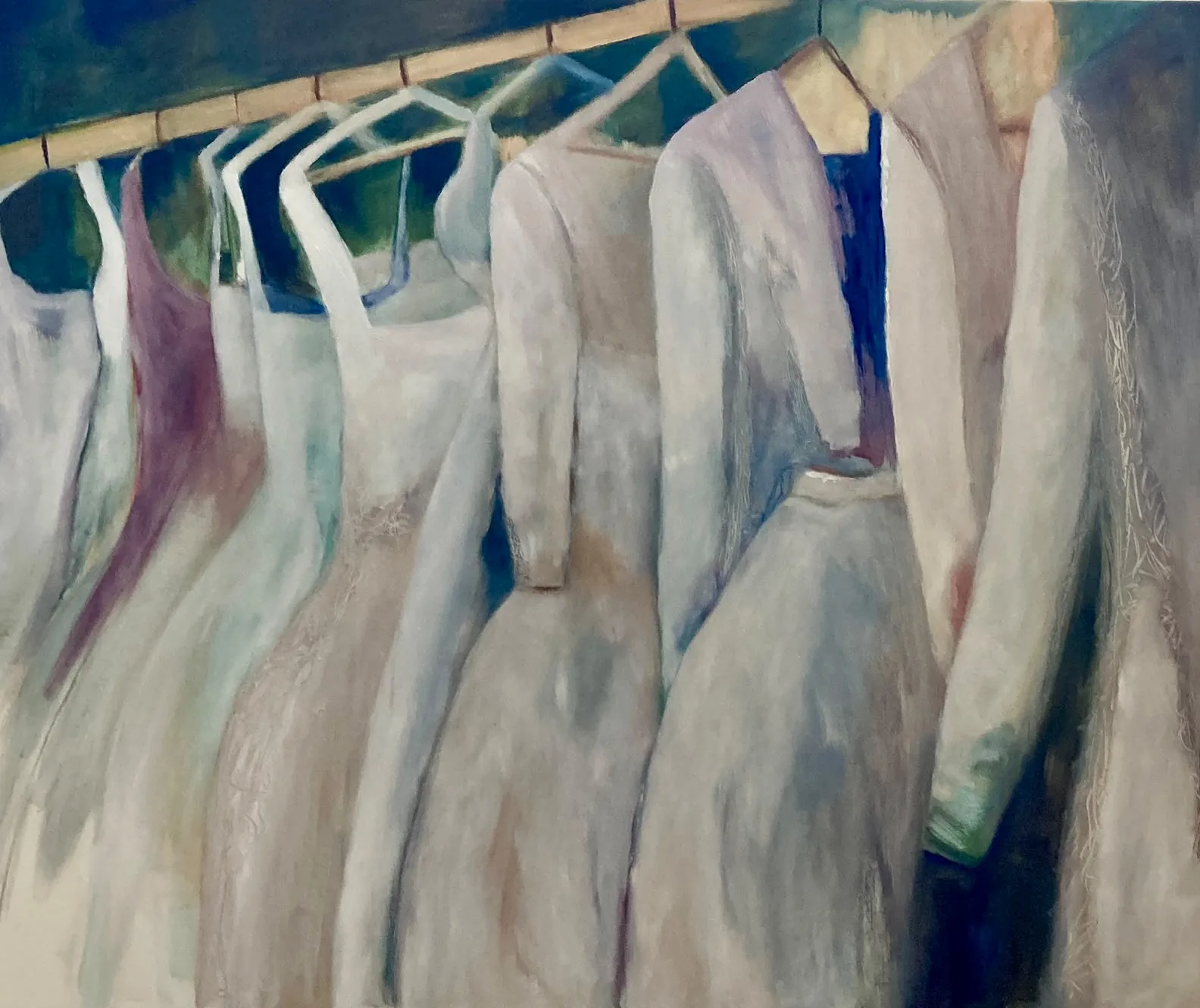 Jurken aan een rek: witte en lichte jurken aan kleerhangers, tegen donkerblauw.